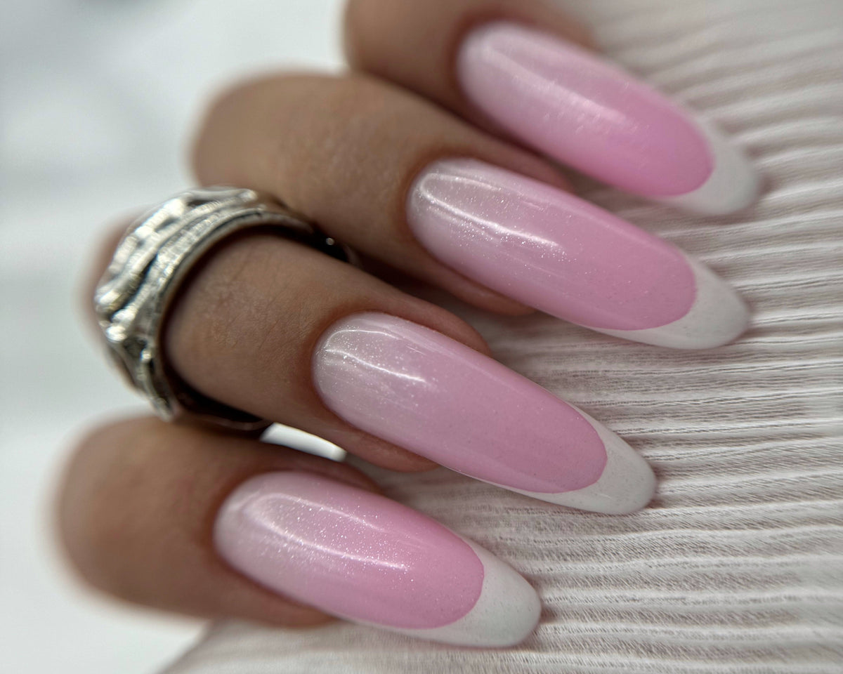 Glow Silver no-wipe top coat shown over a manicure with luminous silver sparkle.