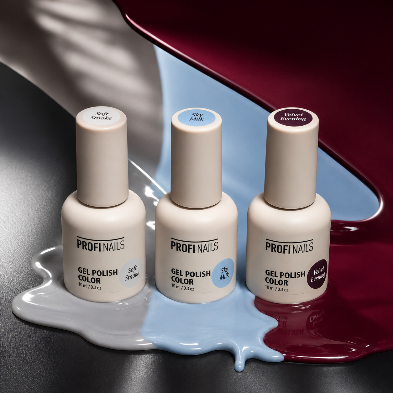 Three bottles of PROFINAILS gel polish color arranged on a glossy dark surface with paint-like drips in white, pale blue, and deep burgundy. The bottles are cream-colored with white caps and labels showing the shade names Soft Smoke, Sky Milk, and Velvet Plum.